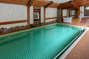 an indoor swimming pool with turquoise water at Hotels am Kranichsee in Hahnenklee-Bockswiese