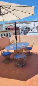 塞維利亞的住宿－Casa El limonero，屋顶上配有遮阳伞的桌椅
