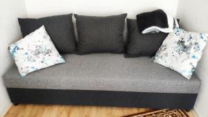 a gray couch with pillows on it in a room at Stropi Apartment Daugavpils in Daugavpils