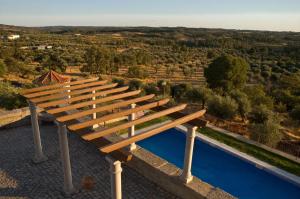 un banco de madera sentado junto a una piscina en Solar dos Caldeira e Bourbon, en Zebras