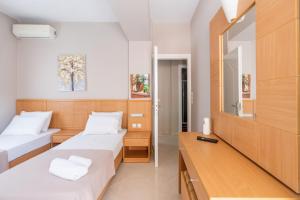 a hotel room with two beds and a mirror at Romeo apartment in Lixouri