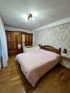 a bedroom with a large white bed with a wall at Areas Gordas in Cangas de Morrazo