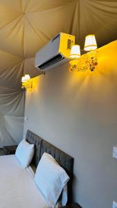 1 dormitorio con 1 cama con proyector en la pared en wadi rum fox road camp & jeep tour en Wadi Rum