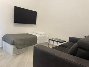 uma sala de estar com uma cama e uma televisão de ecrã plano em Residenze Niguarda E em Milão