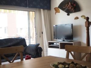 ein Wohnzimmer mit Fernseher und Tisch in der Unterkunft Casa en Malgrat, cerca de la playa in Malgrat de Mar