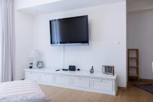 Vestidor blanco con TV de pantalla plana en la pared en City Vibe Villa with pool, en Split
