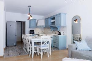 Una cocina con gabinetes azules y una mesa y sillas. en City Vibe Villa with pool, en Split