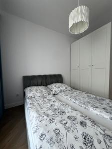 1 dormitorio con 1 cama con manta blanca y negra en Tani Nocleg Ełk - Apartament I love Ełk, en Ełk