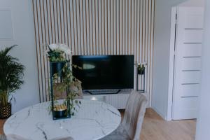a room with a table with a television on a wall at SowaSMART Apartament z sauną in Wolibórz +12 photos