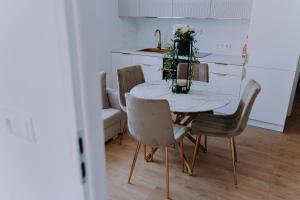 a dining room table with chairs and a vase of flowers at SowaSMART Apartament z sauną in Wolibórz
