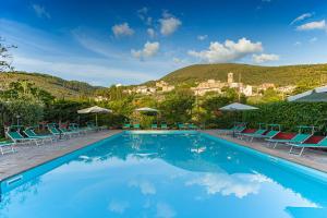 a large swimming pool with chairs and umbrellas at Agriturismo Collelignani in Spoleto