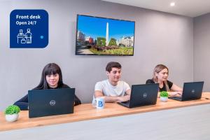 three people sitting at a table with their laptops at Modern Apartments in Puerto Madero in Buenos Aires