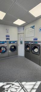 a laundry room with three washing machines in it at Le pat' toit in Aurec-sur-Loire