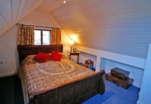 1 dormitorio con 1 cama con 2 almohadas rojas en Doonreagan West Wing, Cashel, en Canower