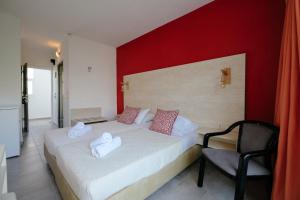 Habitación de hotel con cama y silla en Helena Hotel, en Rodas