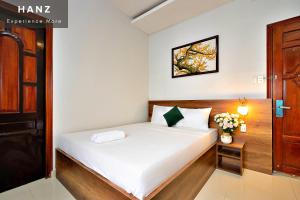a bedroom with a bed with white sheets at Thu Khoa Huan Hotel in Ho Chi Minh City
