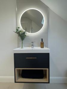 een badkamer met een wastafel en een spiegel bij Two Bedroom Deluxe Sea View Guest Suite in Inis Mor