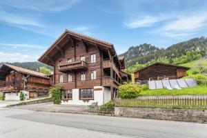 une grande maison en bois sur le côté d'une route dans l'établissement App. Seeblick Top of Interlaken, à Beatenberg