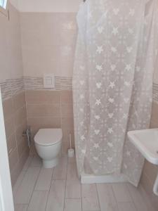 a bathroom with a toilet and a shower curtain at Villa Rosa in Castellammare del Golfo