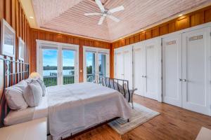 a bedroom with a bed and a ceiling fan at Roosevelt Cottage in Captiva +32 photos
