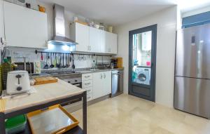 a kitchen with white cabinets and a stainless steel refrigerator at Beautiful Apartment In Torrevieja in Torrevieja