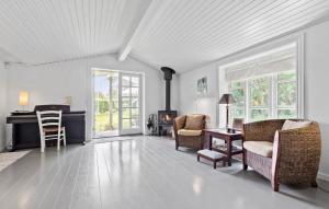 a living room with chairs and a table and a fireplace at Lovely Home In Vejby With Kitchen in Vejby