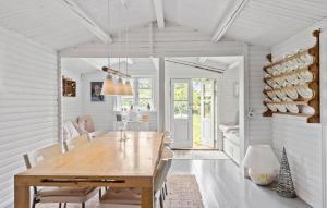 a dining room with a wooden table and chairs at Lovely Home In Vejby With Kitchen in Vejby +14 photos