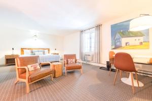 a bedroom with a bed and chairs and a painting at Innsbruck Inn at Stowe in Stowe