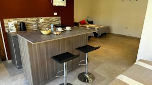a kitchen with a bar with two stools and a sink at Tiny House Chacras in Chacras de Coria