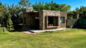 a stone house with a window in a yard at Tiny House Chacras in Chacras de Coria