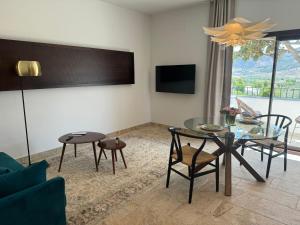 a living room with a table and chairs and a tv at CASA YANGUAS APARTAMENTOS RURALES EN LAUJAR DE ANDARAx in Laujar de Andarax