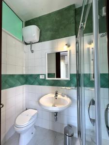 baño verde y blanco con aseo y lavamanos en Agriturismo Colle Maiano en Vietri