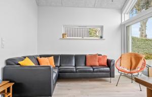 Un sofá de cuero negro con almohadas de colores en una sala de estar. en Awesome Home In Hejls, en Hejls