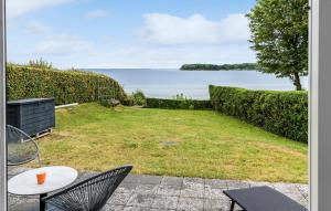 Un patio con mesa y sillas y el mar. en Awesome Home In Hejls, en Hejls 10 fotos más