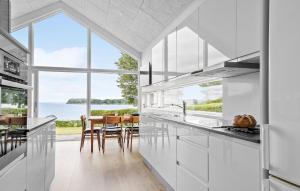 Una cocina con gabinetes blancos y una ventana grande. en Awesome Home In Hejls, en Hejls