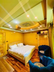 um quarto com uma cama e 2 cadeiras em North Palace Khaplu em Khaplu