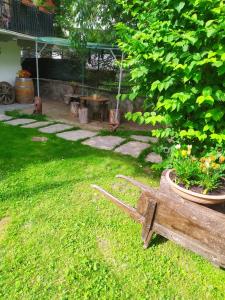 Sparone的住宿－La Ghita，一个带木凳和一盆鲜花的花园