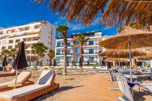 a beach with chairs and umbrellas and a hotel at Sea View Apartments ELDO in Durrës