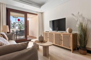 Una sala de estar con televisión y un sofá. en Penthouse Bahia de la Plata, en Estepona