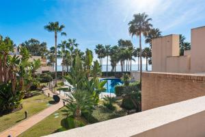 - Vistas a un complejo con palmeras y piscina en Penthouse Bahia de la Plata, en Estepona