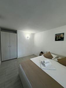 een witte slaapkamer met een groot bed en een kast bij Vila Yzabelle in Eforie Nord