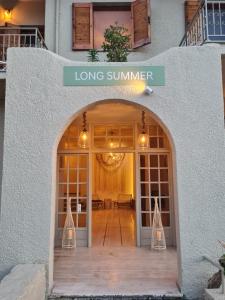 a long summer sign on a building with a large doorway at LONG SUMMER in Sivota