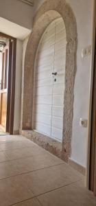 una puerta de garaje blanca en una habitación con suelo de baldosa en Apartments & Rooms Nada, en Brseč