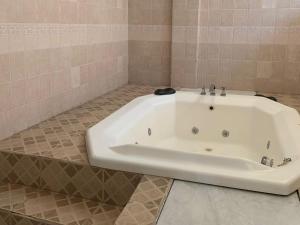 uma banheira branca na casa de banho com piso em azulejo em Hotel Sol em Termas de Rio Hondo