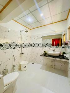 een witte badkamer met een wastafel en een toilet bij North Palace Khaplu in Khaplu