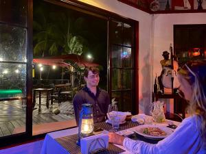 un homme et une femme assis à une table dans un restaurant dans l'établissement Plantage Resort Frederiksdorp, à Paramaribo