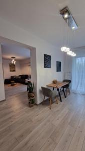 a living room with a table and a dining room at Appartment Chindia Lake in Târgovişte