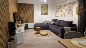 a living room with a purple couch and a table at Appartment Chindia Lake in Târgovişte