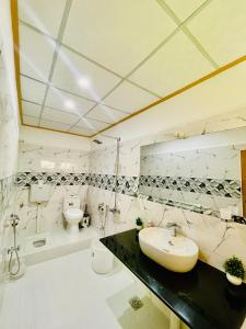 a white bathroom with a sink and a toilet at North Palace Khaplu in Khaplu
