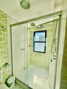 uma casa de banho com uma cabina de duche em vidro e um WC. em Flat Mar Montanha Four Seasons no Rio de Janeiro